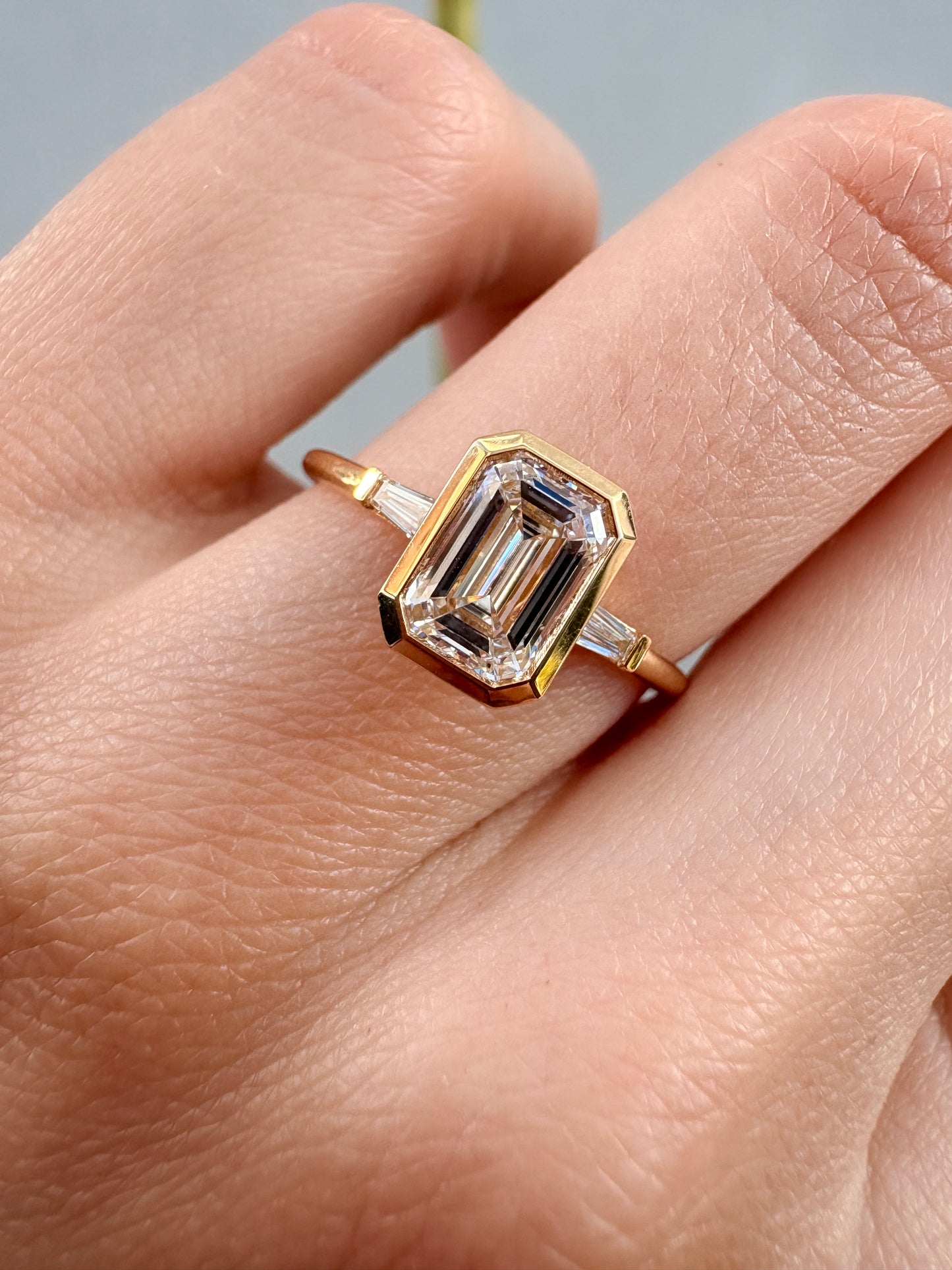 18K EMERALD CUT DIAMOND BEZEL THREE STONE RING